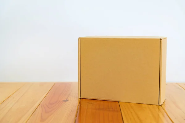 Άδειο κουτί από χαρτόνι καφέ σε ξύλινο τραπέζι με χώρο αντίγραφο. — Φωτογραφία Αρχείου
