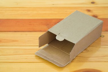 Ahşap masa üzerinde sahte için kahverengi karton kutu boş açıldı