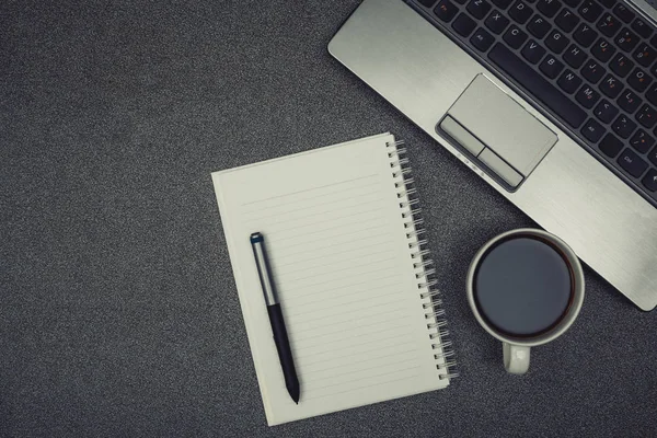 Laptop computer or notebook, note and cup of coffee on working t