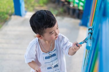 Üzgün Asyalı çocuk kaçmaya çalışırken ızgara arkasında. sığ Dof