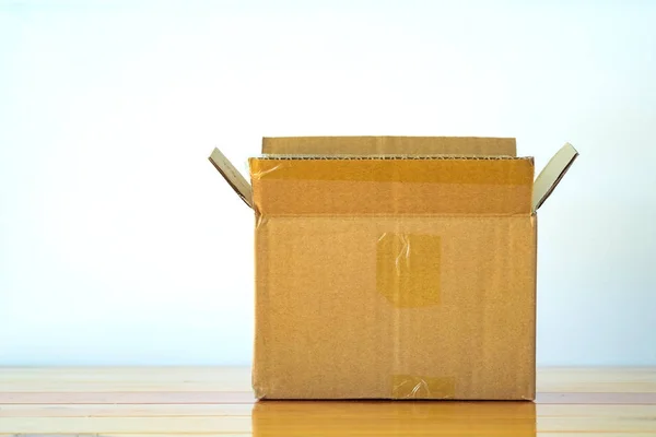 Empty opened old brown cardboard box for mock up on the wooden t — Stock Photo, Image