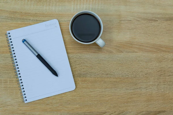Una tazza di caffè con annotazione e penna sul tavolo di lavoro con centro benessere copia — Foto Stock