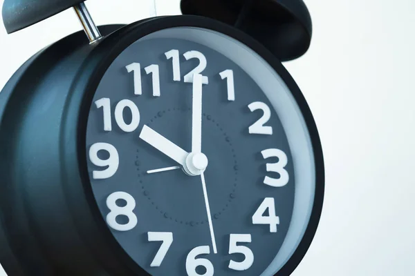 Close up de cor preta relógio de alarme vintage na parede branca, tempo — Fotografia de Stock