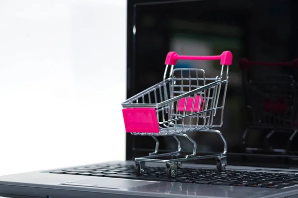 Shopping cart eller stormarknad vagn med laptop anteckningsboken på whi — Stockfoto