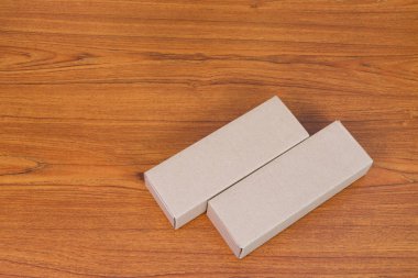 Ahşap masa uzun maddelerle boş paket kahverengi karton kutu