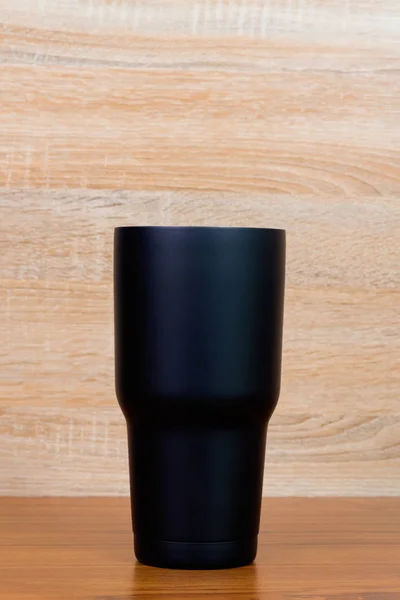 Copo de aço inoxidável de cor preta ou copo de armazenamento frio em madeira — Fotografia de Stock