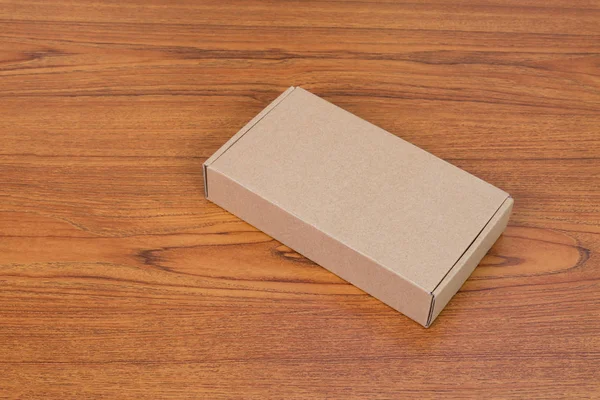 Пустой коричневый картонный ящик или поднос для макета на деревянном столе — стоковое фото