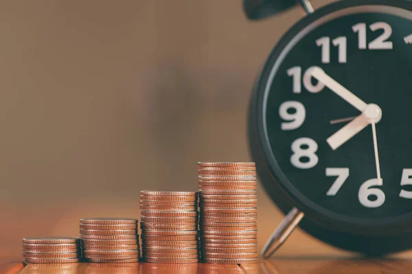 Alarm clock and step of coins stacks on working table, time for — Stock Photo, Image
