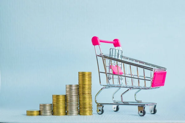 Passo de pilhas de moedas e carrinho de compras ou carrinho de supermercado — Fotografia de Stock