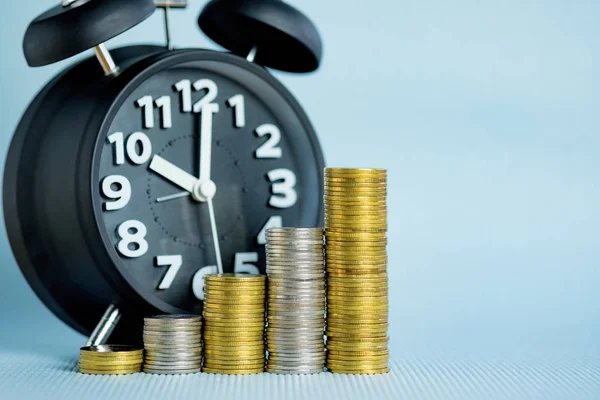 Wekker en stap van munten stapels, tijd voor besparingen geld con — Stockfoto