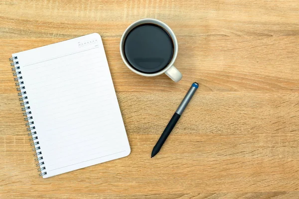 Una tazza di caffè con annotazione e penna sul tavolo di lavoro con centro benessere copia — Foto Stock