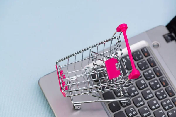 Shopping cart eller stormarknad vagn med laptop anteckningsboken på gre — Stockfoto