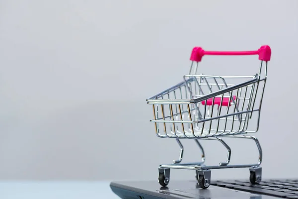 Кошик або візок супермаркету з ноутбуком на сірому — стокове фото