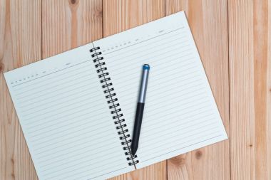 Defter kalem kopya alanı görünümle ahşap masa üstü ile.