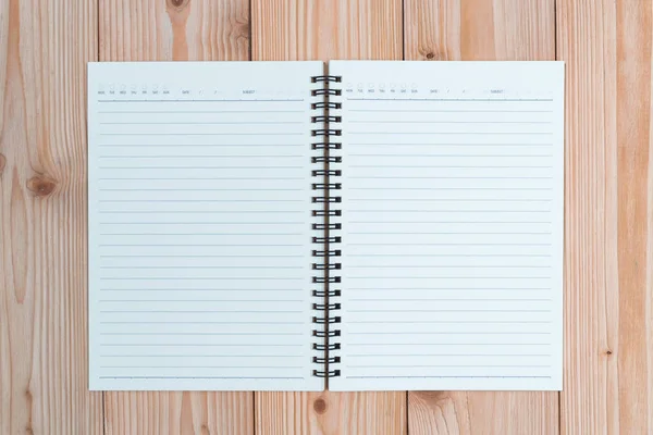 Cuaderno sobre tabla de madera vista superior con espacio para copiar . — Foto de Stock