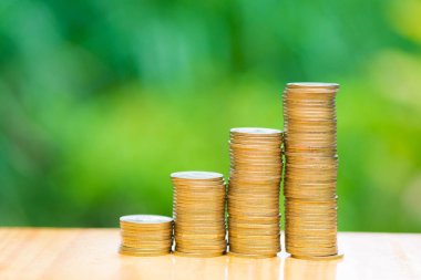 Büyüyen paralar yığınlar yeşil ağaç bokeh arka plan ile. Finansal