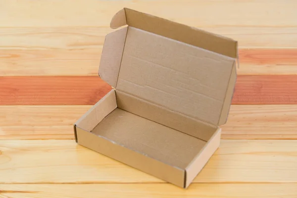 Пустой коричневый картонный ящик на деревянном столе с местом для копирования . — стоковое фото
