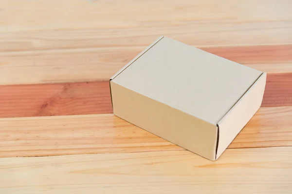 Пустой коричневый картонный ящик на деревянном столе с местом для копирования . — стоковое фото