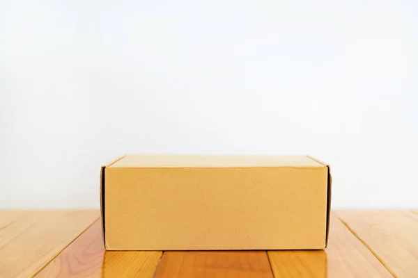 Caja de cartón marrón vacía sobre mesa de madera con espacio para copiar . —  Fotos de Stock