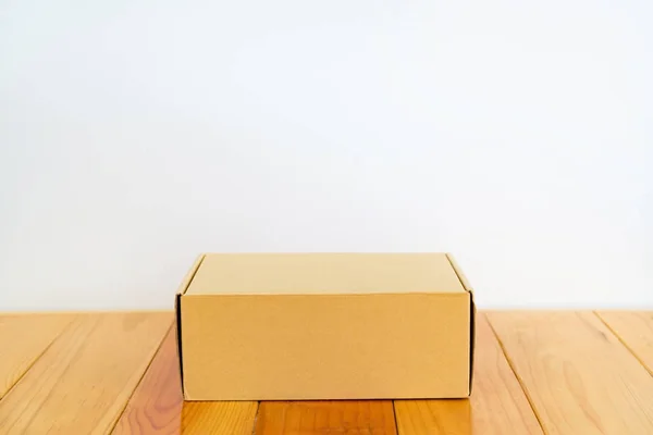 Caixa de papelão marrom vazia na mesa de madeira com espaço de cópia . — Fotografia de Stock