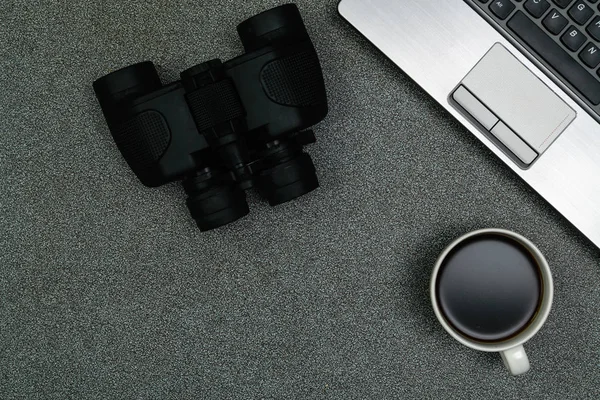 Computador portátil ou notebook, binocular e xícara de café no trabalho — Fotografia de Stock