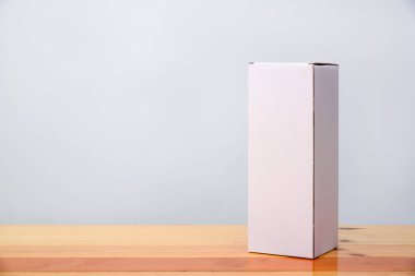 Ahşap masa uzun maddelerle boş paket beyaz karton kutu