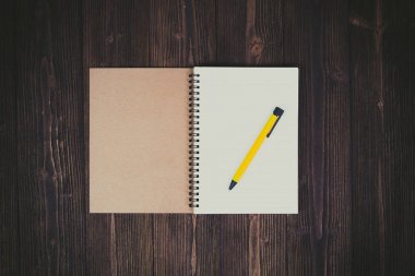 Defter ve kalem ahşap masa üstüne boş beyaz kağıt w görüntülemek