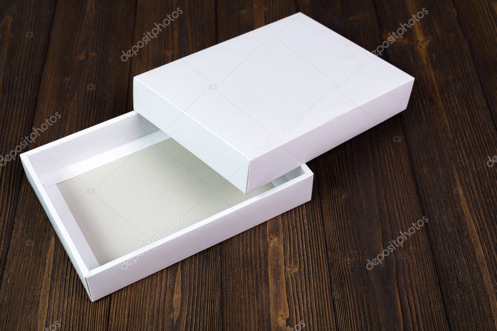 Empty white gift box or tray for mock up on dark wooden table wi