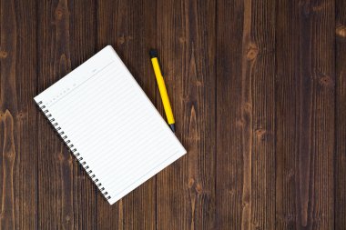 Defter ve kalem ahşap masa üstüne boş beyaz kağıt w görüntülemek