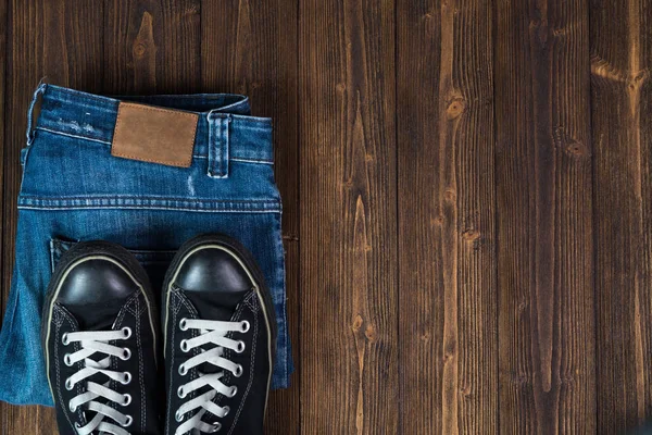 Kot pantolon ya da kot denim koleksiyonu ve siyah spor ayakkabı o yıpranmış