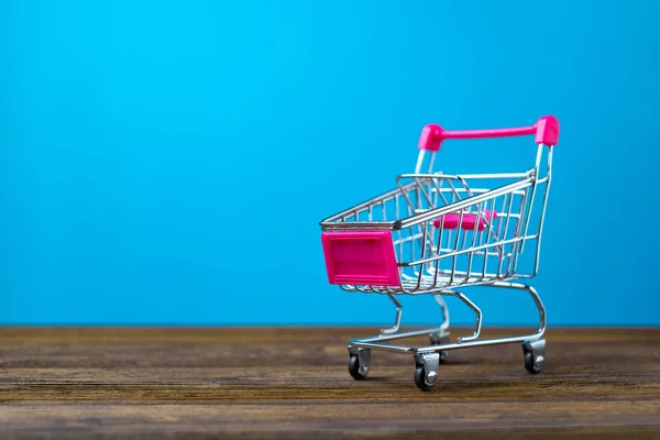 Shopping cart eller stormarknad vagn på träbord med kopia s — Stockfoto