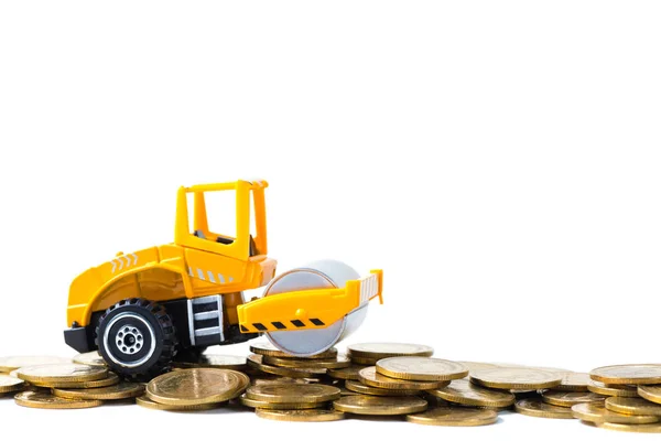 Mini Road roller machine with stack coin with pile of gold coin, Stock Photo