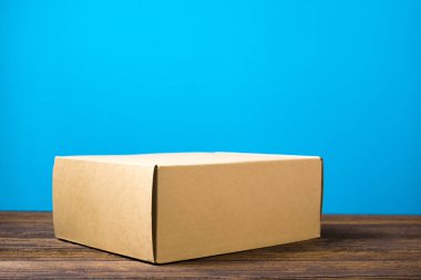 Koyu ahşap tabl üzerinde sahte için kahverengi karton kutu boş kapandı