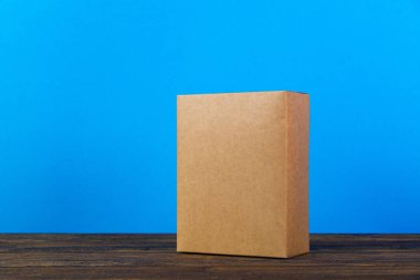 Koyu ahşap tabl üzerinde sahte için kahverengi karton kutu boş kapandı