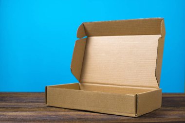 Koyu ahşap tabl üzerinde sahte için kahverengi karton kutu boş kapandı