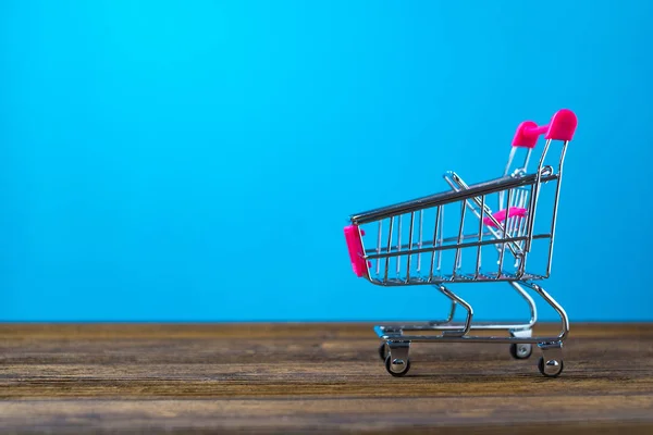 Shopping cart eller stormarknad vagn på träbord med kopia s — Stockfoto