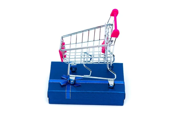 Blå presentask med band rosett och shopping cart eller stormarknad t — Stockfoto