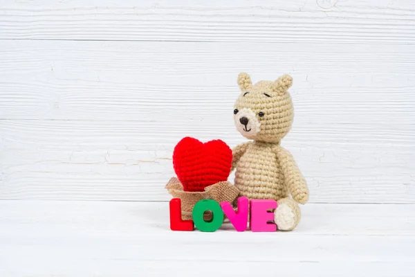 Söt nalle docka med kärlek text och röd stickning hjärtat på — Stockfoto