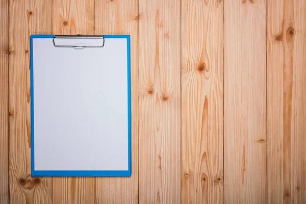 Portapapeles con hoja de papel blanco en blanco sobre tabla de madera vista superior wi — Foto de Stock