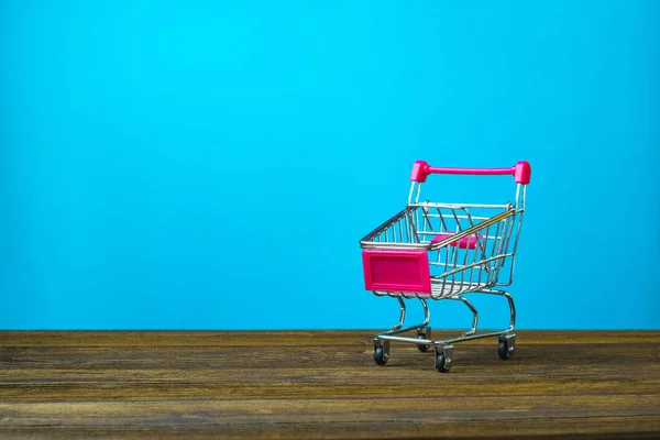 Shopping cart eller stormarknad vagn på träbord med kopia s — Stockfoto