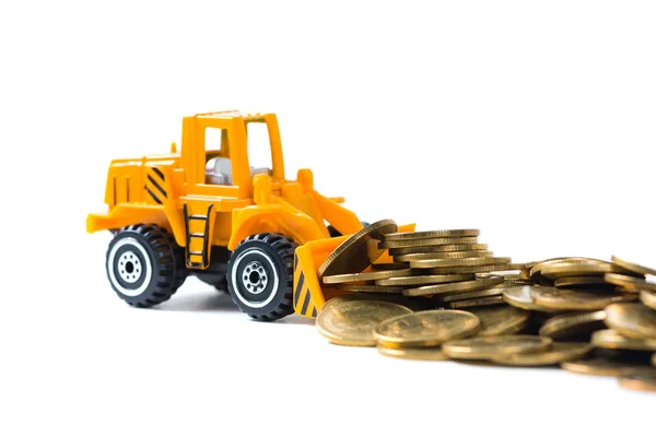 Mini bulldozer truck loading stack coin with pile of gold coin, Stock Photo