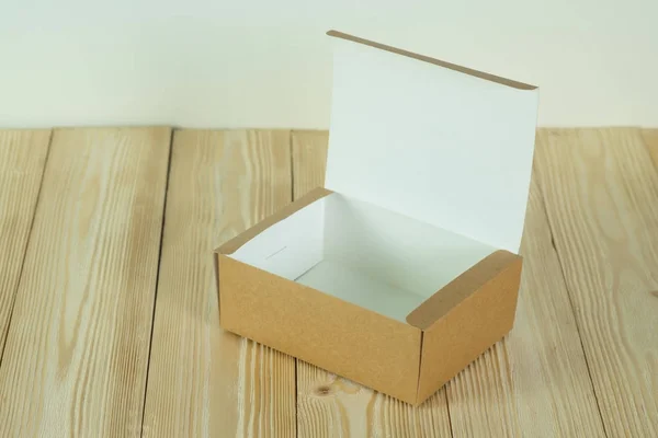 Caixa de papelão marrom aberta vazia para simular na mesa de madeira — Fotografia de Stock