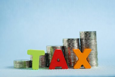 Vergi kavramı. Madeni para yığını ile ahşap yapılmış Word vergi alfabesi