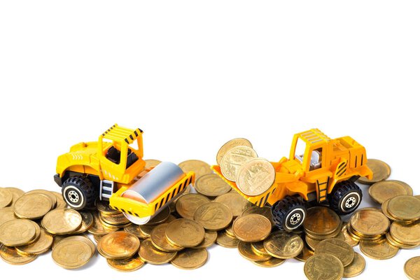 Mini Road roller machine with pile of gold coin, isolated on whi