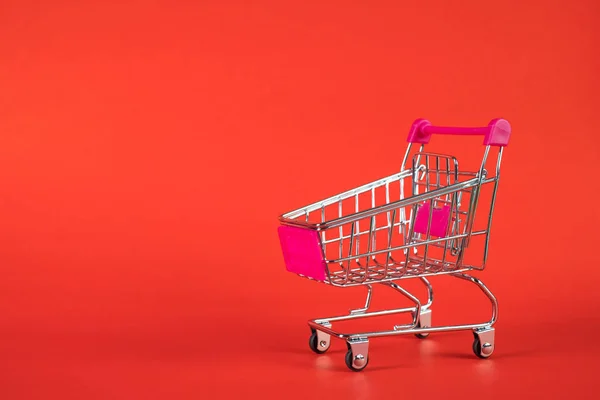 赤の背景、ビジネスにショッピング カートやスーパー マーケットのトロリー — ストック写真