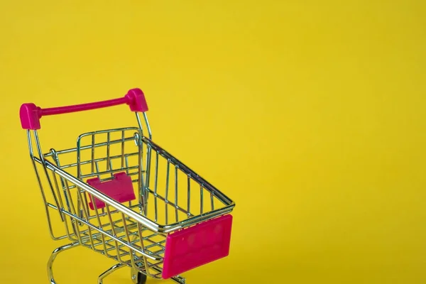 Shopping cart eller stormarknad vagn på gul bakgrund, busin — Stockfoto