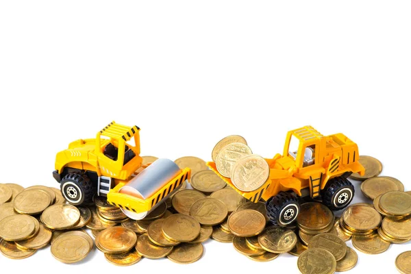 Mini Road roller machine with pile of gold coin, isolated on whi Royalty Free Stock Images