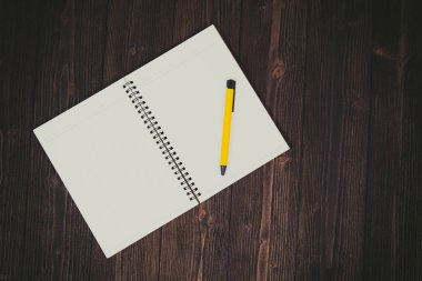 Defter ve kalem ahşap masa üstüne boş beyaz kağıt w görüntülemek