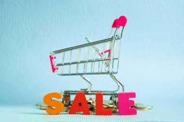 Satılık renkli ahşap metin ve üzerinde mavi arka plan ile kopya alanı, indirim ve merketing kavram fikir alışveriş sepeti ya da süpermarket arabası alışveriş. Şablon için metin veya fotoğraf ekleme.