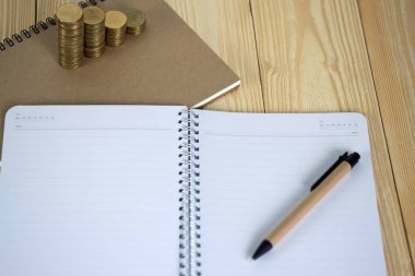 Ahşap çalışma masa kopya alanı için metin, mali ve iş planlama kavramı fikri ile hakkında defter kağıt paralar adımlardan yığını.